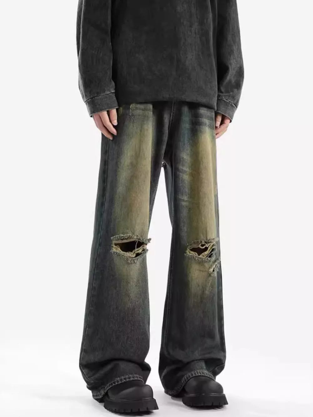 Men's wide-leg jeans with distressed details and ripped knees in a vintage wash.