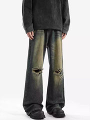 Men's wide-leg jeans with distressed details and ripped knees in a vintage wash.