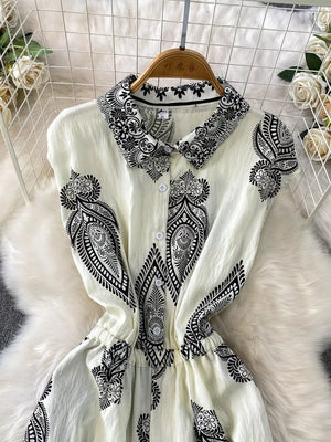 White collared button-down romper with black paisley print and cinched waist.
