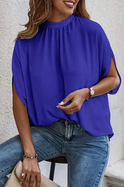Royal blue blouse with draped sleeves and a mock neckline.