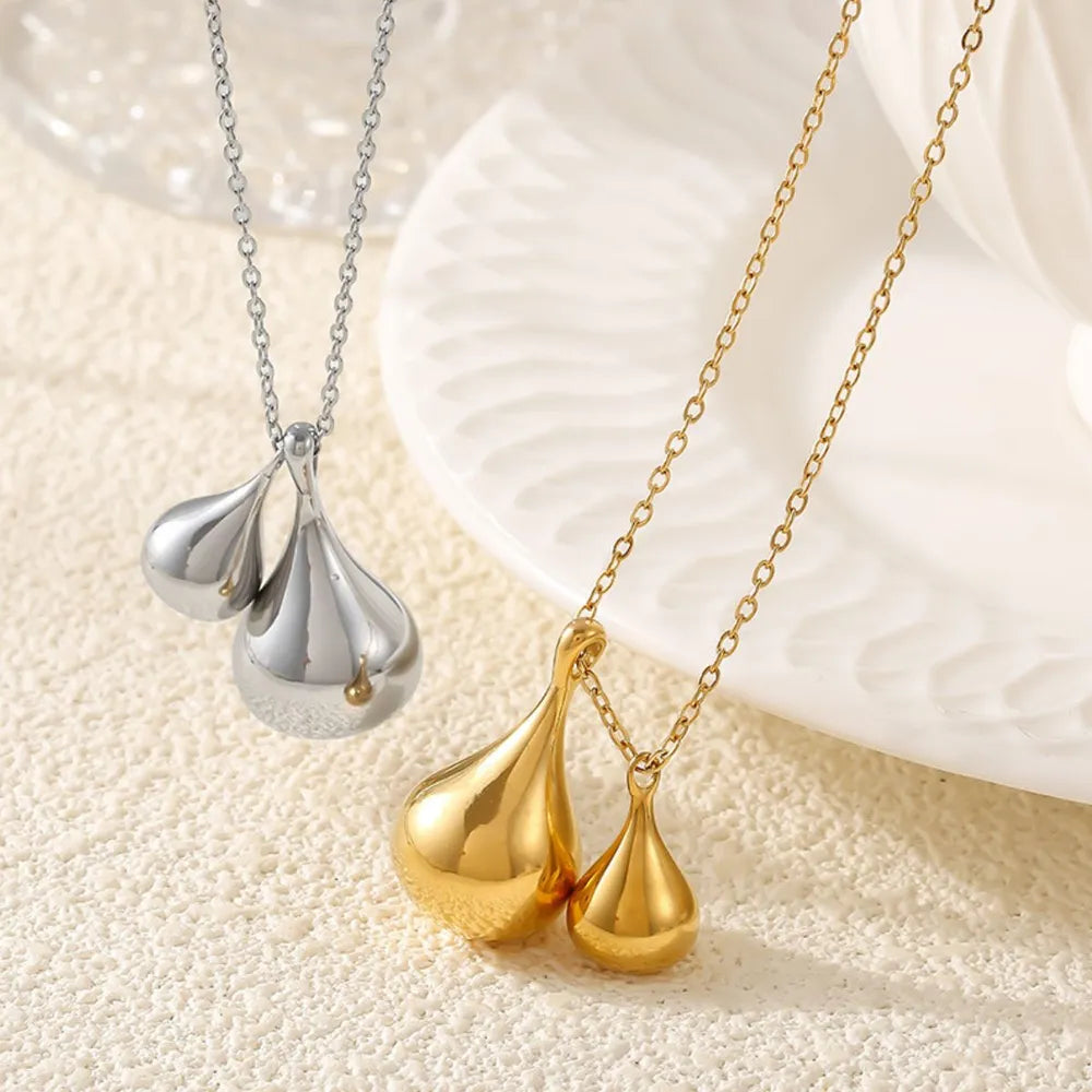 Gold and silver necklaces with polished teardrop pendants, a chic duo.