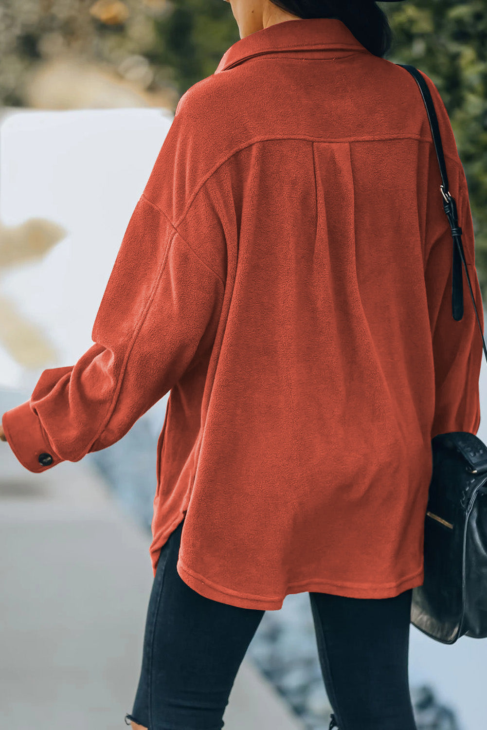 Fleece shirt jacket in orange with button cuffs and side pockets.