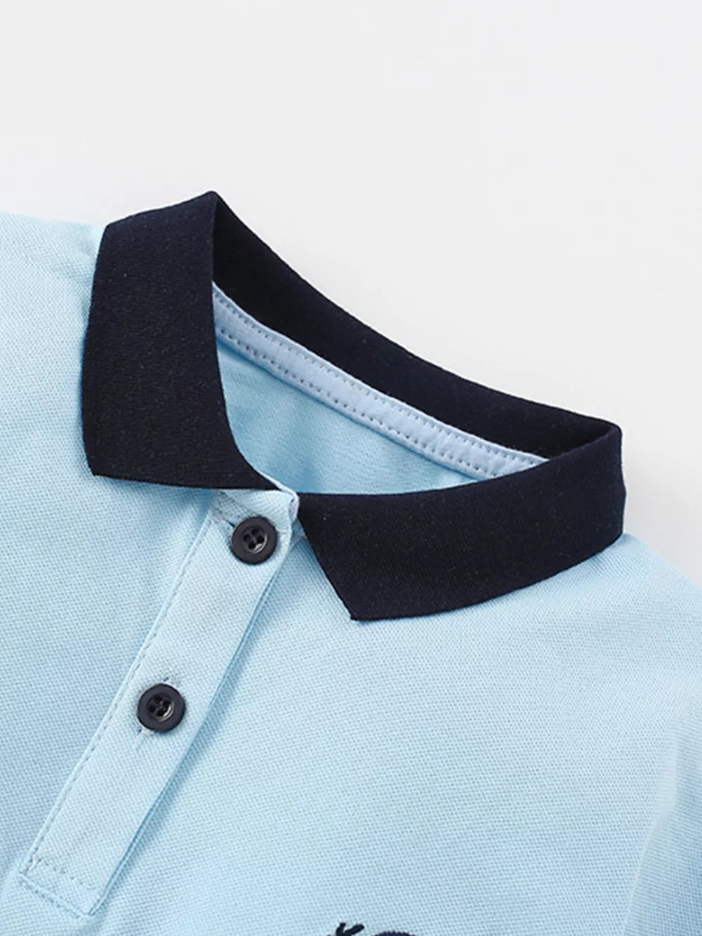 Light blue cotton polo shirt with navy collar and two buttons.