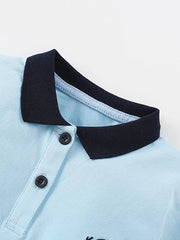 Light blue cotton polo shirt with navy collar and two buttons.