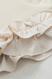 Beige ribbed mock neck top with ruffled sleeve detail.