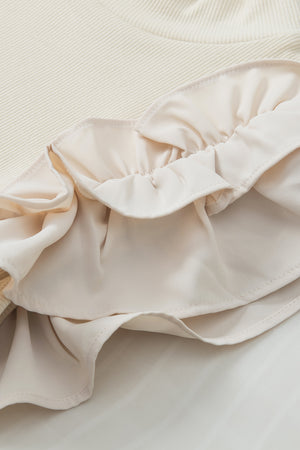 Beige ribbed mock neck top with ruffled sleeve detail.