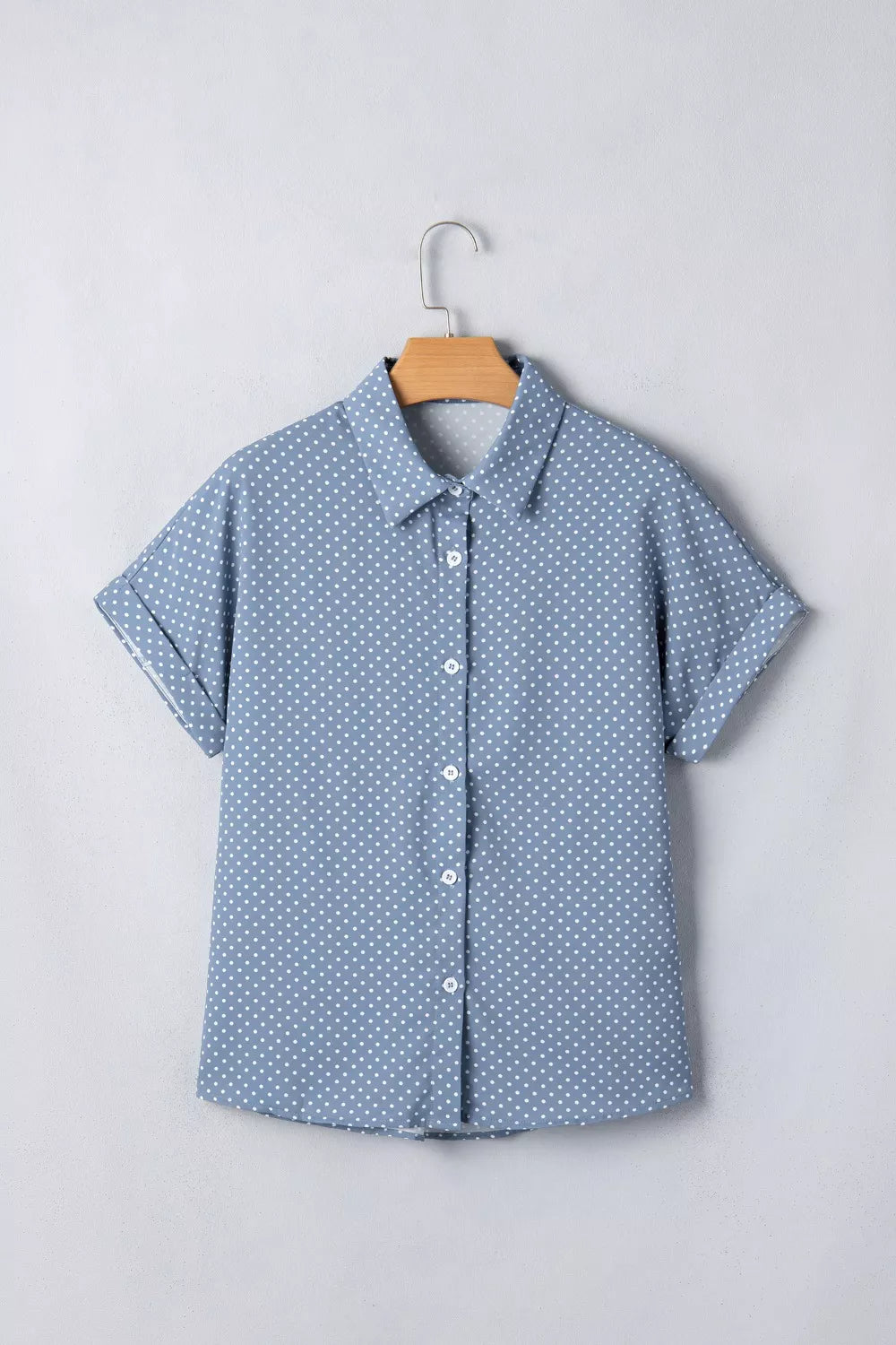 Blue polka dot short sleeve polyester shirt with cuffed sleeves and button front.