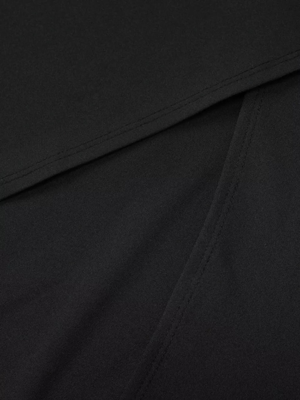 Black maxi dress detail showing seam and fabric texture.