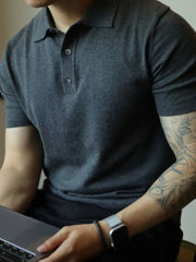 Dark gray fine-gauge knit polo shirt with a refined placket and button detail.