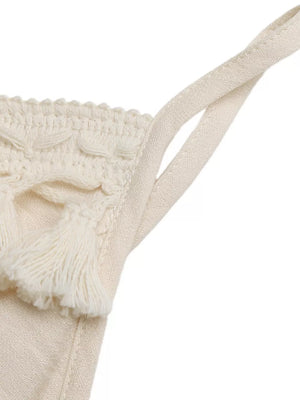 Cream lace-trimmed spaghetti strap romper with tassels.