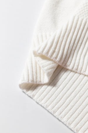 Diamond cable knit sweater in white with ribbed texture and folded detail.