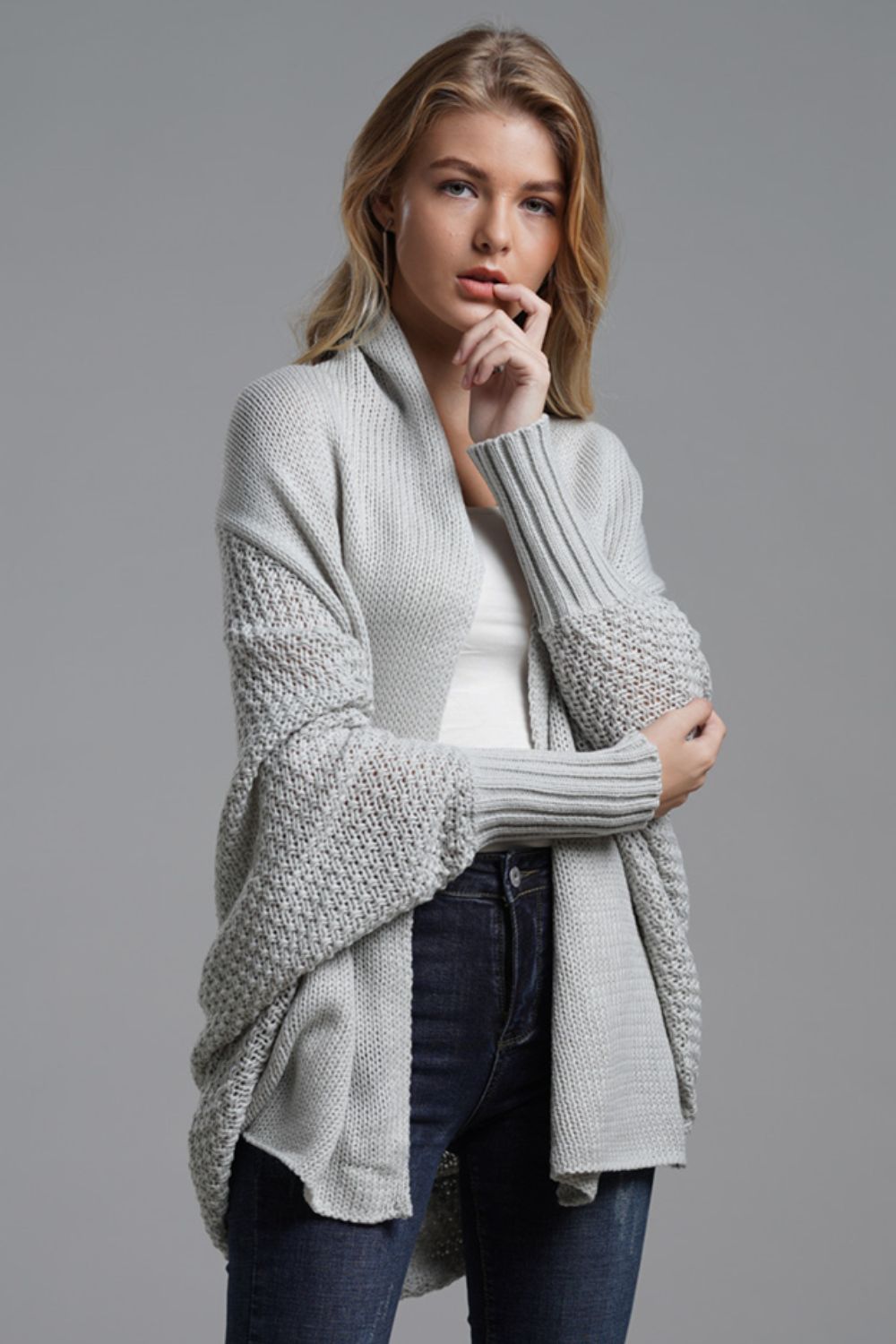 Gray batwing knit cardigan with drape front and textured sleeves.