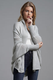 Gray batwing knit cardigan with drape front and textured sleeves.