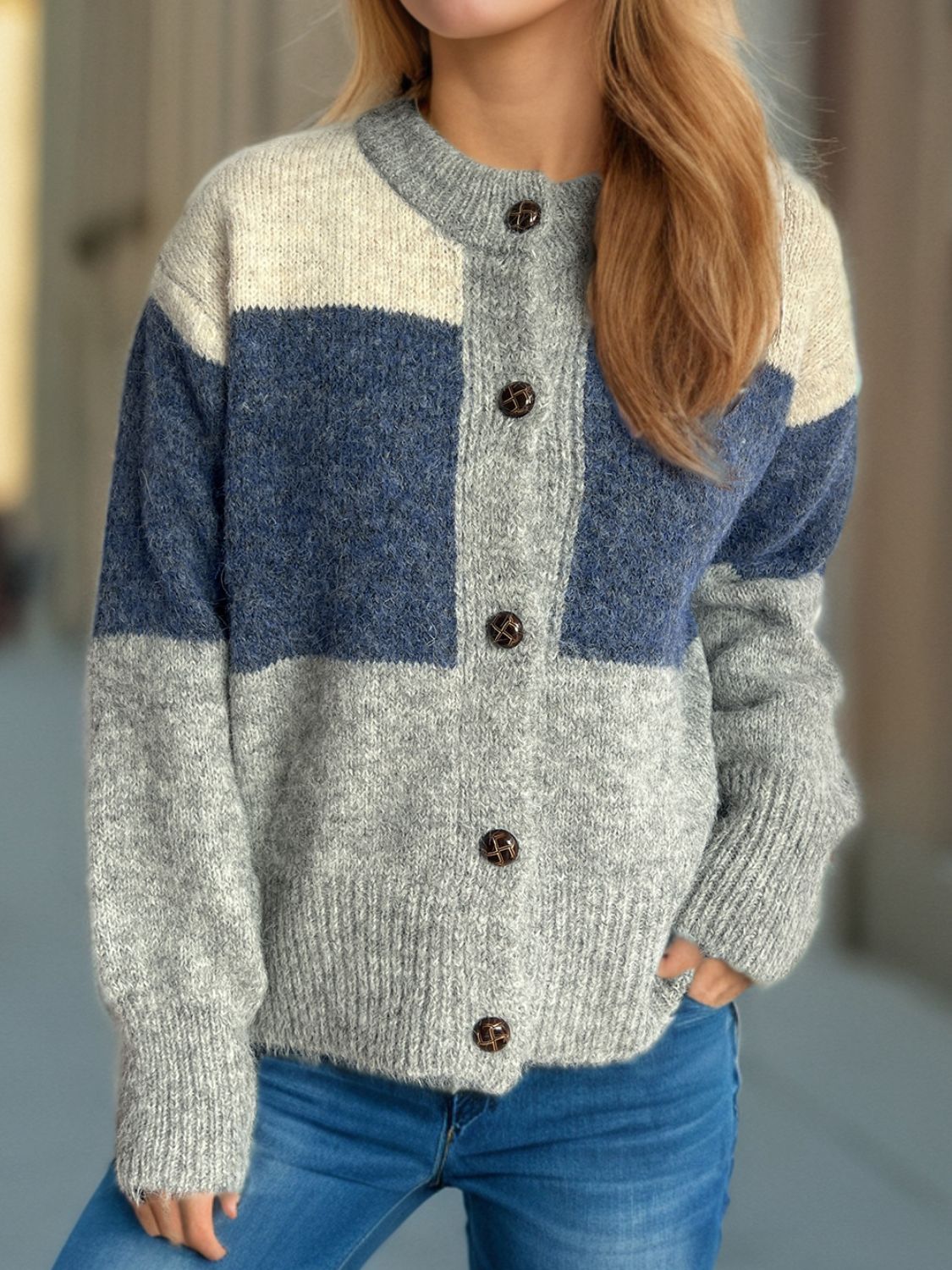 Colorblock crewneck button-down knit cardigan with blue, beige, and gray blocks.