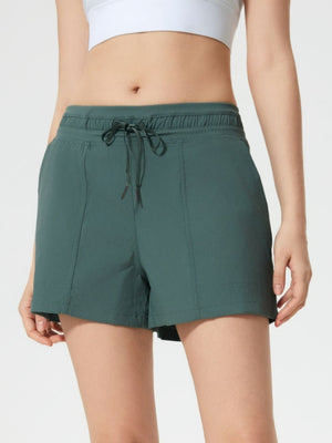 Coastal drawstring utility shorts in dark green with elastic waistband and tie.