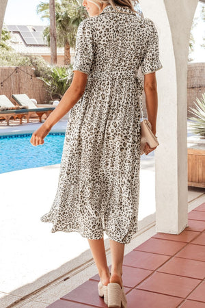 Print button-down midi dress with short sleeves and a drawstring waist, featuring a leopard print.