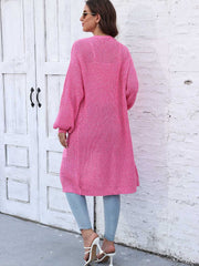 Pink ribbed knit maxi cardigan with pockets and balloon sleeves.