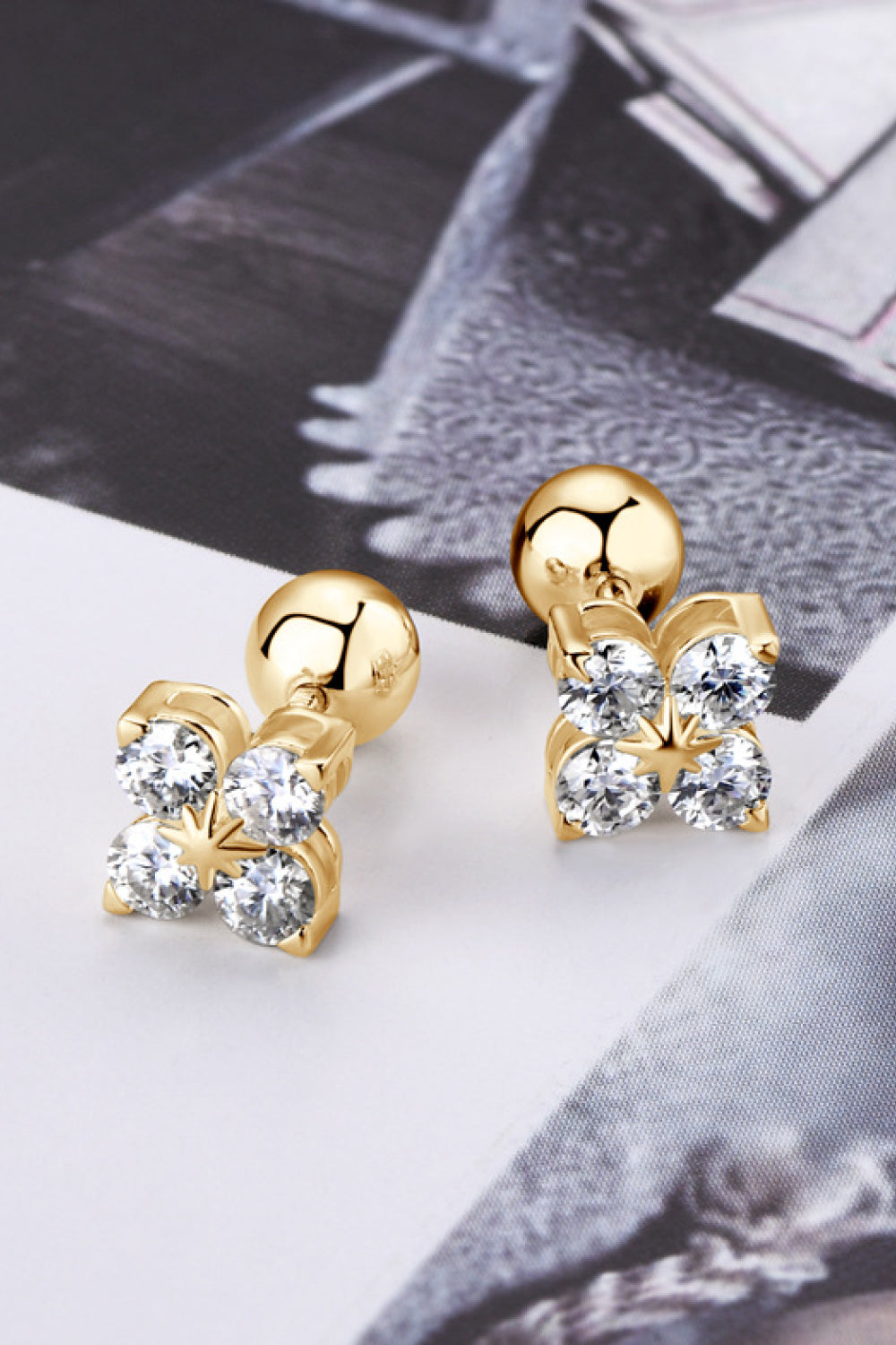 Gold four-stone stud earrings with clear cubic zirconia in a clover design.