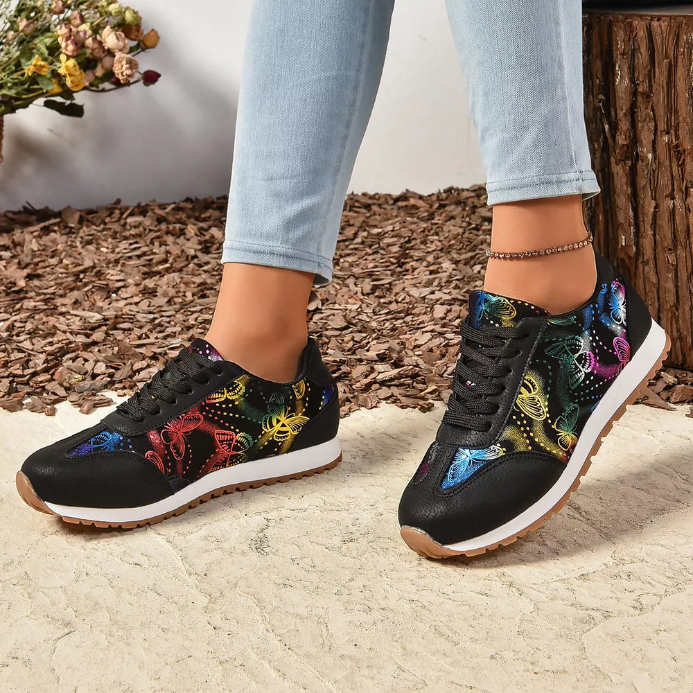 Black casual sneakers with a vibrant rainbow butterfly print and white soles.