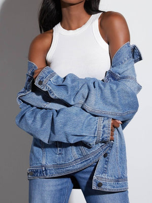 Denim trucker jacket in medium wash with collared neckline and button closure, styled casually.