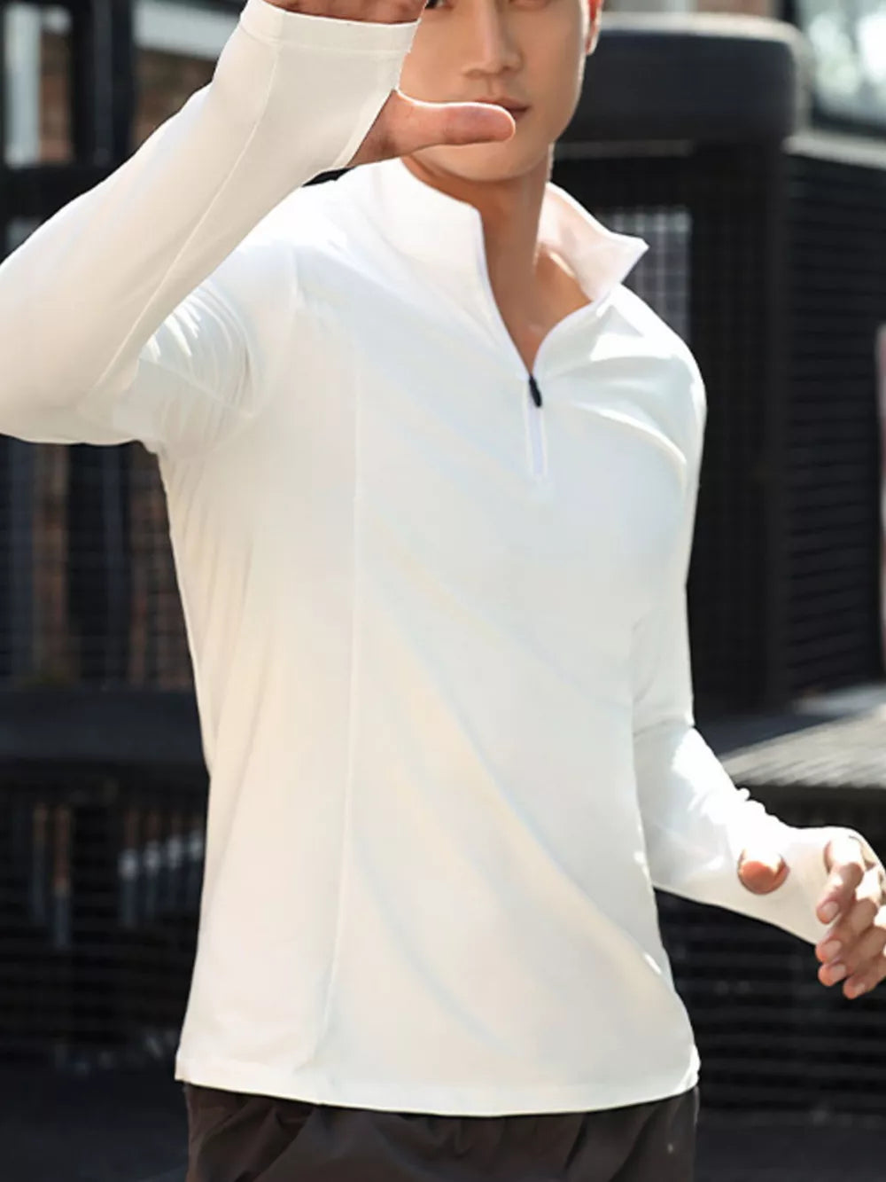 Men's white quarter-zip active t-shirt with thumbholes and a breathable fit.