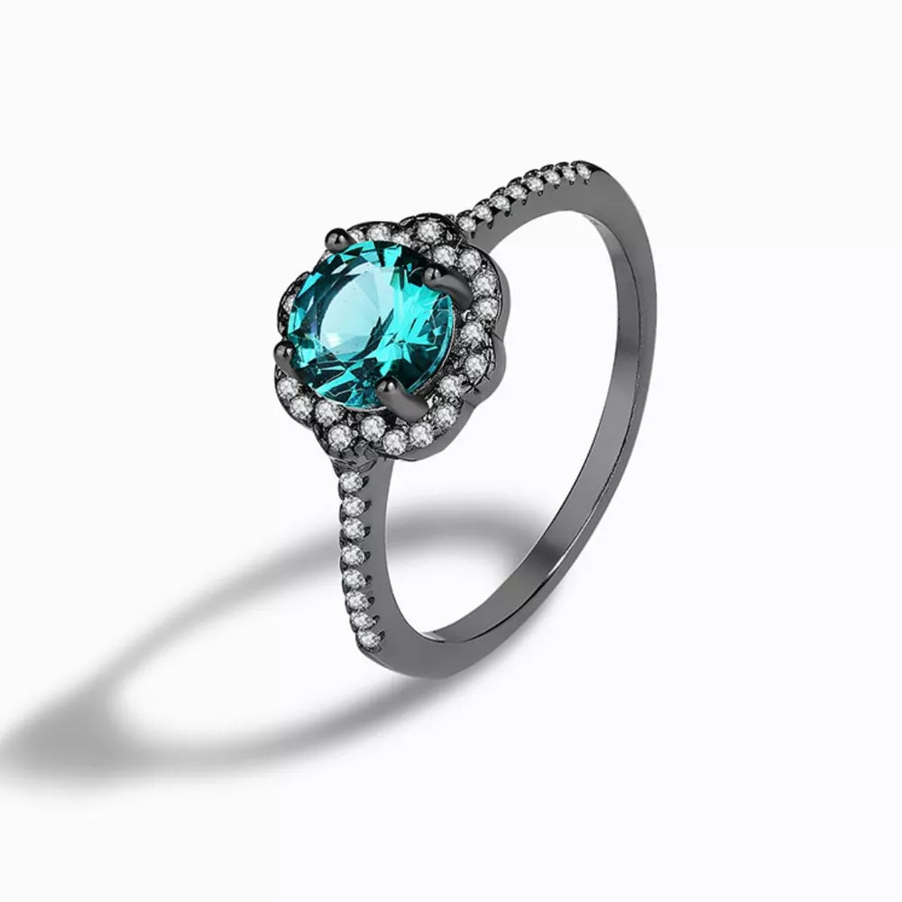Elegant sterling silver ring with a teal zircon and diamond halo.