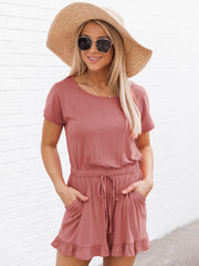 Blush pink romper with ruffle hem and drawstring waist, short sleeves, crew neck.