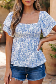 Floral babydoll shirt with ruffled sleeves and square neckline, smocked waist, blue and white print