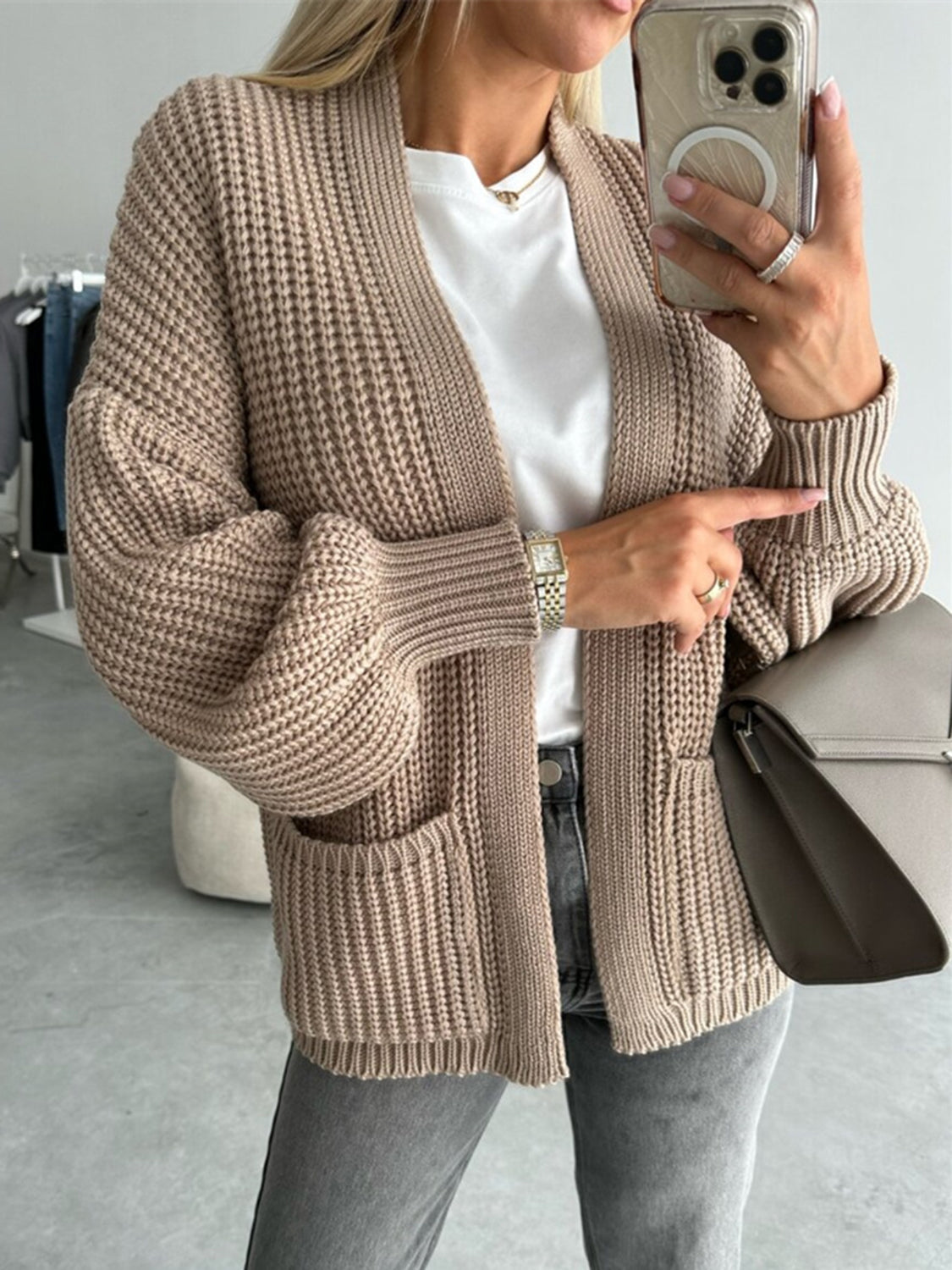 Beige textured puff sleeve cardigan with pockets and ribbed cuffs.