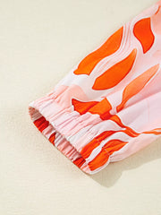 Vibrant abstract print mini dress with elasticated cuff and tiered detail.