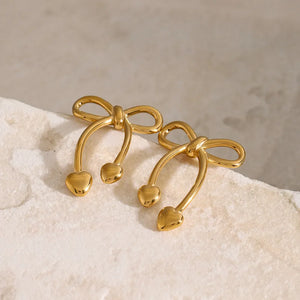 Gold heart-tipped bow drop earrings with delicate curves.