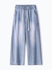 Men's light wash wide-leg jeans with drawstring waist and vintage fade detail.