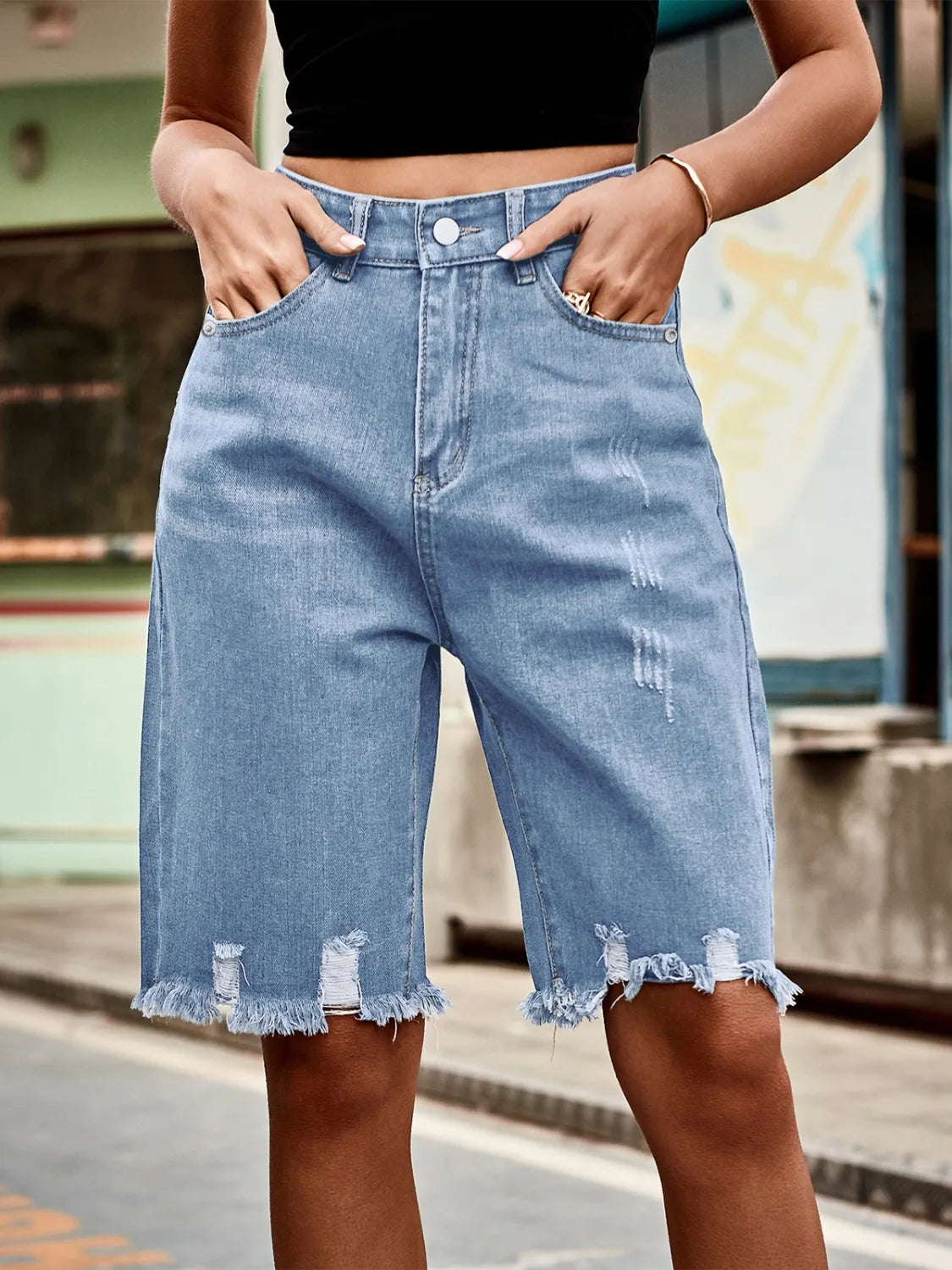 Light blue denim cutoff shorts with distressed details and frayed hem
