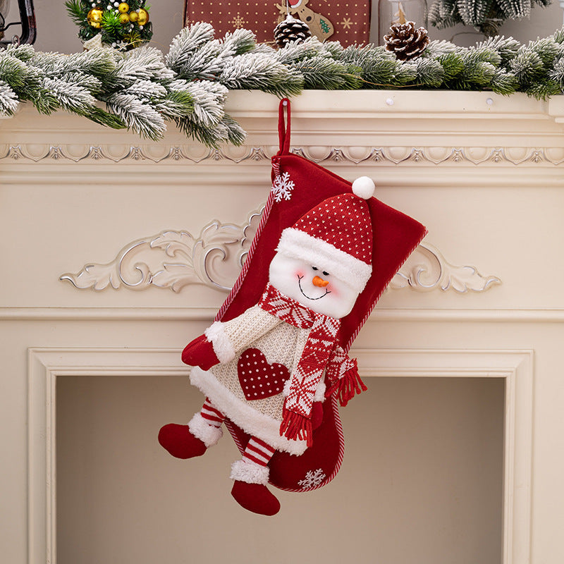 Red Christmas stocking with plush snowman detail, festive scarf and hat.