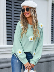Mint green knit sweater with daisy appliqués and balloon sleeves.