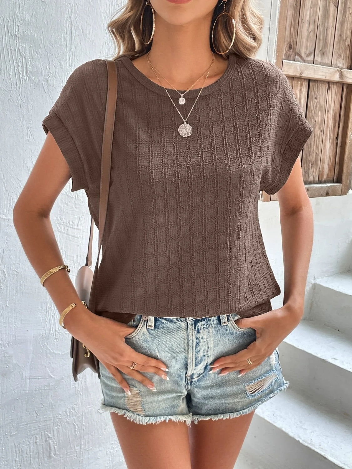 Tan woven texture cap-sleeve blouse with a crew neck and relaxed fit.