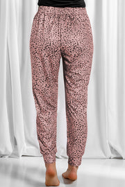 Dusty pink leopard print jogger trousers with elastic waistband and cuffed ankles.