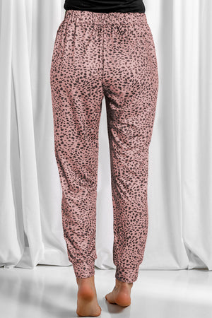 Dusty pink leopard print jogger trousers with elastic waistband and cuffed ankles.