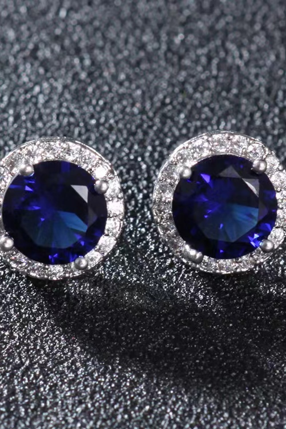 Sapphire halo stud earrings with diamond accents and silver settings.