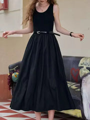 Black midi dress with a fitted sleeveless top and a flowing skirt, cinched with a belt.