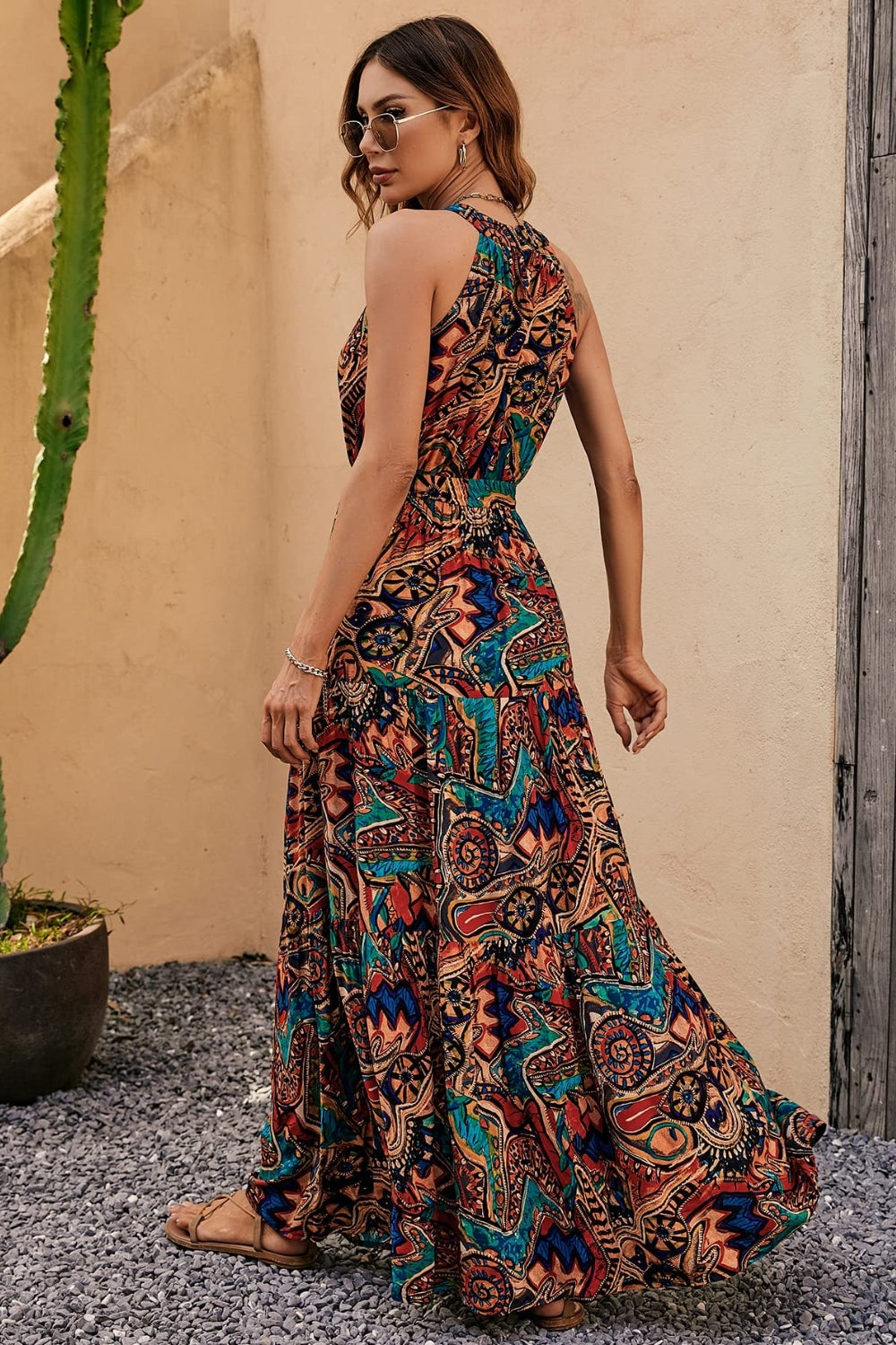 Halter neckline maxi dress with a vibrant paisley print in brown, green, and blue tones.