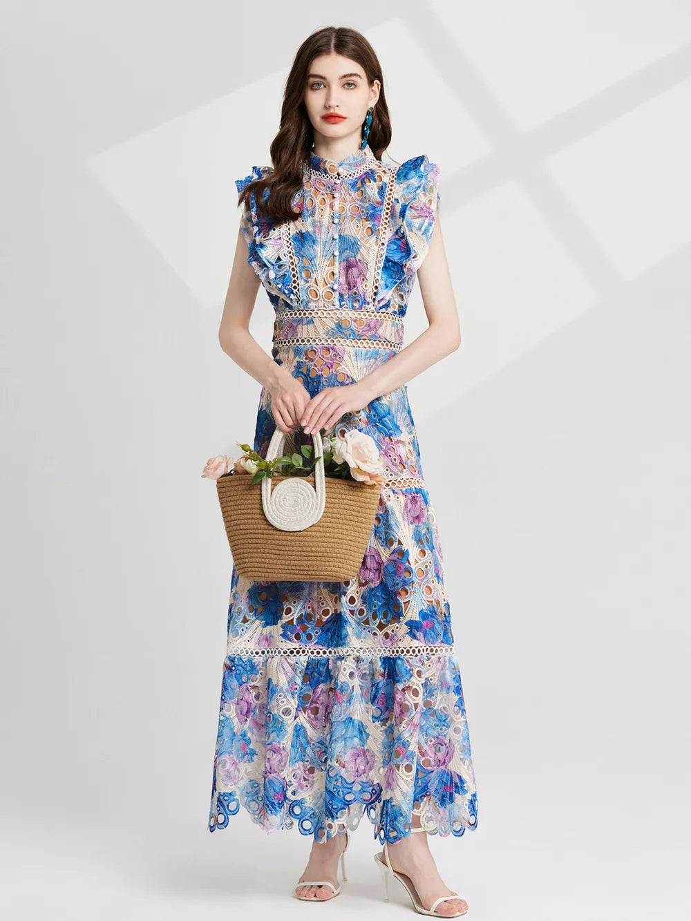 Maxi dress with floral lace cutout details in blue and purple, featuring ruffled sleeves and a high neckline.