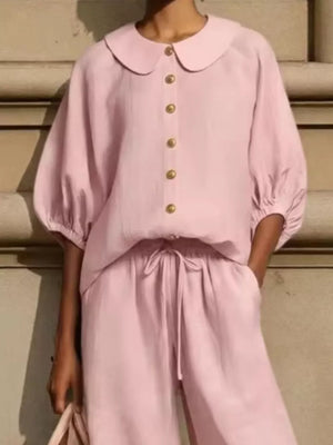 Pink linen two-piece set with button-down top and drawstring pants.