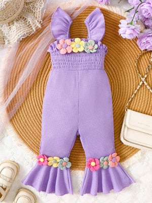 Purple baby jumpsuit with smocked bodice, ruffle straps, and floral applique on neckline and flared legs.