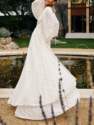 White maxi dress with balloon sleeves and a wave pattern, featuring a tiered skirt.