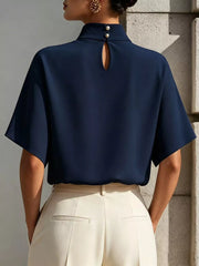 Navy mock neck t-shirt with relaxed sleeves, pearl button closure, and keyhole cutout.