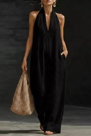 Black halter-neck pocketed maternity jumpsuit with deep V-neck and wide legs.