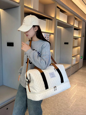 Luxurious quilted travel duffel bag in creamy-white with brown straps and black accents.