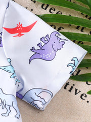 Toddler white cotton shirt with blue, purple, and red dinosaur print.
