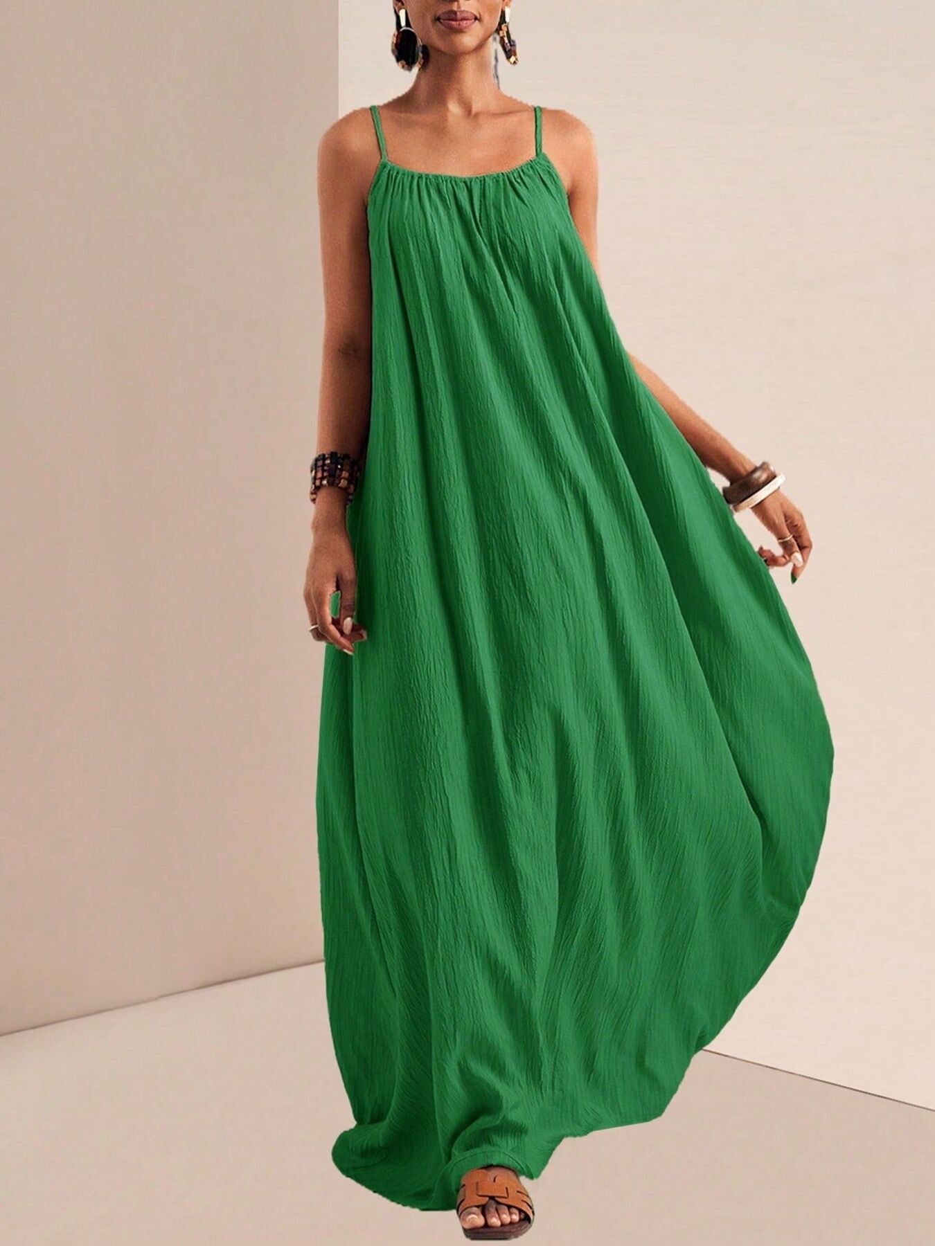 Green crinkled maxi dress with spaghetti straps and a flowy skirt.